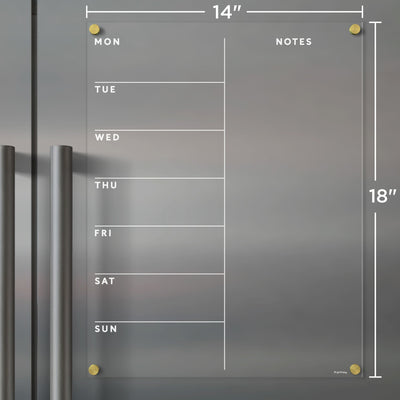The Girl Friday Clear Acrylic Fridge Calendar is an elegant 14x18 planner with daily columns and a notes section. Mounted on gray with gold pegs, its compatible with wet-erase markers for easy updates.