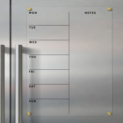 The Clear Acrylic Weekly Fridge Calendar | Week and Notes by Girl Friday is a minimalist planner with columns for Monday to Sunday, a notes section on the right, and can be mounted on metallic surfaces. It pairs perfectly with wet-erase markers and includes two metallic handles for easy handling.