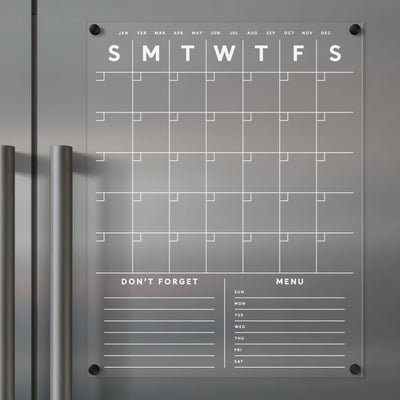 The Clear Acrylic Monthly Fridge Calendar by Girl Friday Shop features sections for each day, plus customizable Dont Forget and Menu areas. Compatible with dry-erase and wet-erase markers, this sleek calendar is perfect for organizing your monthly activities.