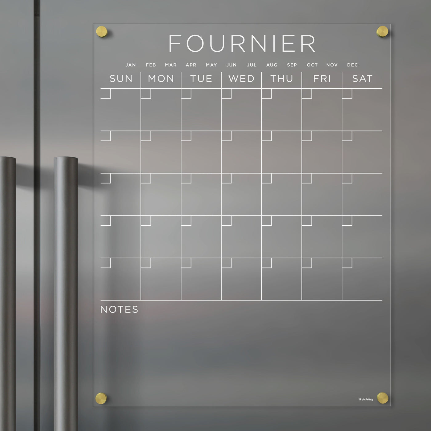Girl Fridays Acrylic Fridge Calendar, customizable with a family name, spans January to December and features a Sunday-to-Saturday layout with a notes section. Designed for use with wet-erase markers, it easily mounts on metallic surfaces.