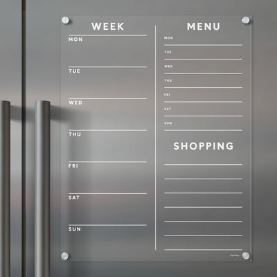 Girl Fridays Acrylic Fridge Planner features a sleek design with customizable Week, Menu, and Shopping columns on a gray background. Monday to Sunday are listed, with note lines included. Its wall-mounted via four corner screws and compatible with dry-erase markers.