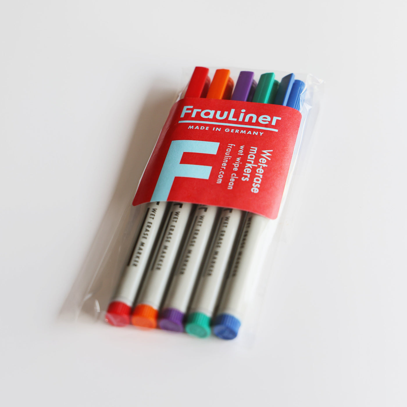 Enhance your Girl Friday acrylic wall calendar with a package of Frauliner whiteboard markers. Perfectly coordinating with its design, these Made in Germany markers are wet-erasable and feature red, orange, green, blue, and purple caps inside packaging with polished edges in red and white branding.