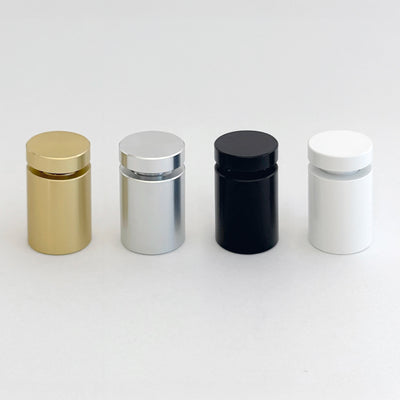 Four cylindrical containers are neatly lined up on a plain background, gleaming in metallic gold, silver, black, and white. Each has a matching round cap and pairs perfectly with accents from your Girl Friday Shops Clear Acrylic Monthly Wall Calendar | Black Text or a clear acrylic board.