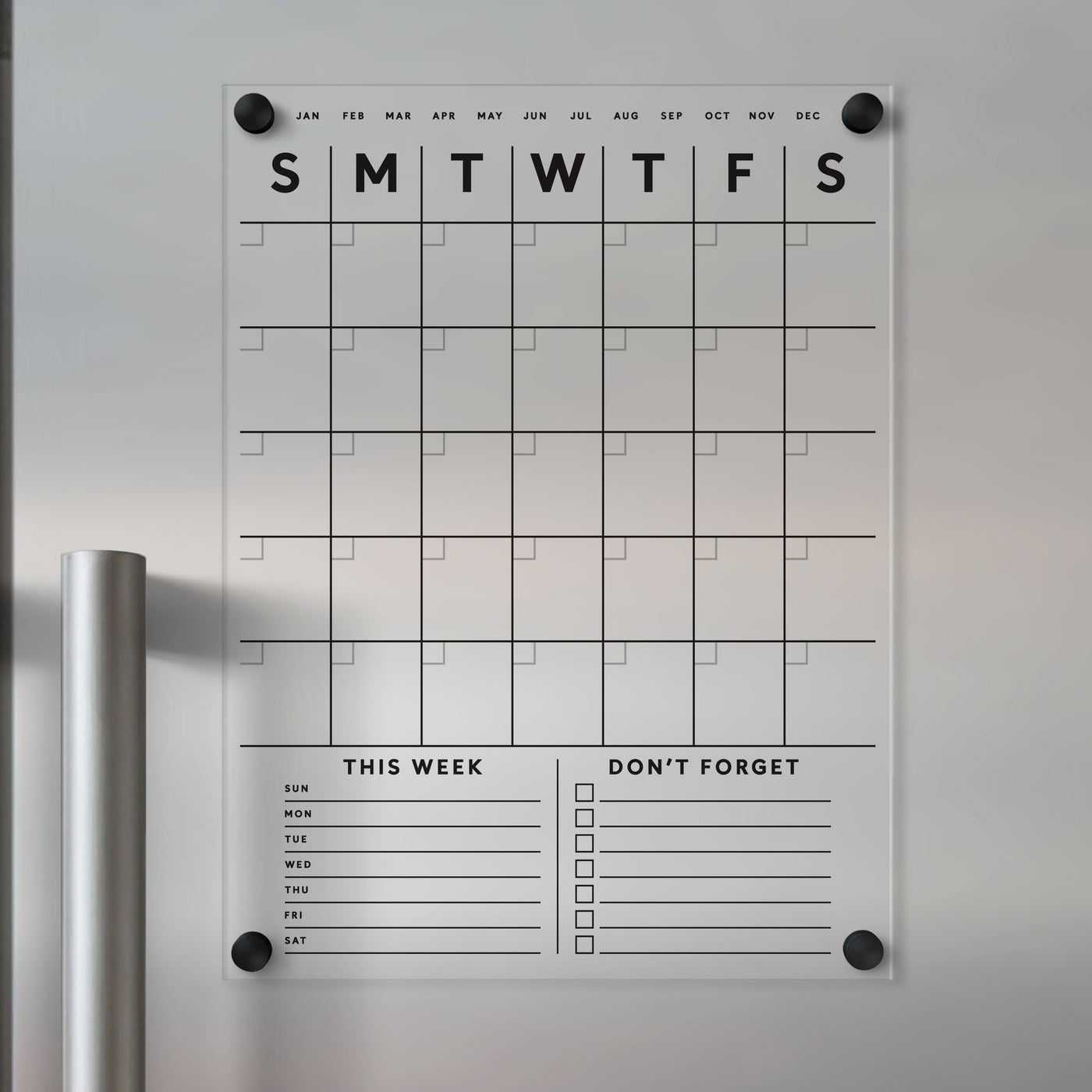 The Clear Acrylic Fridge Calendar by Girl Friday Shop is a minimalist, magnet-mounted acrylic calendar for your fridge. It features black text with a grid layout, days of the week, This Week and Dont Forget sections, plus lines and checkboxes for customization with wet-erase markers.
