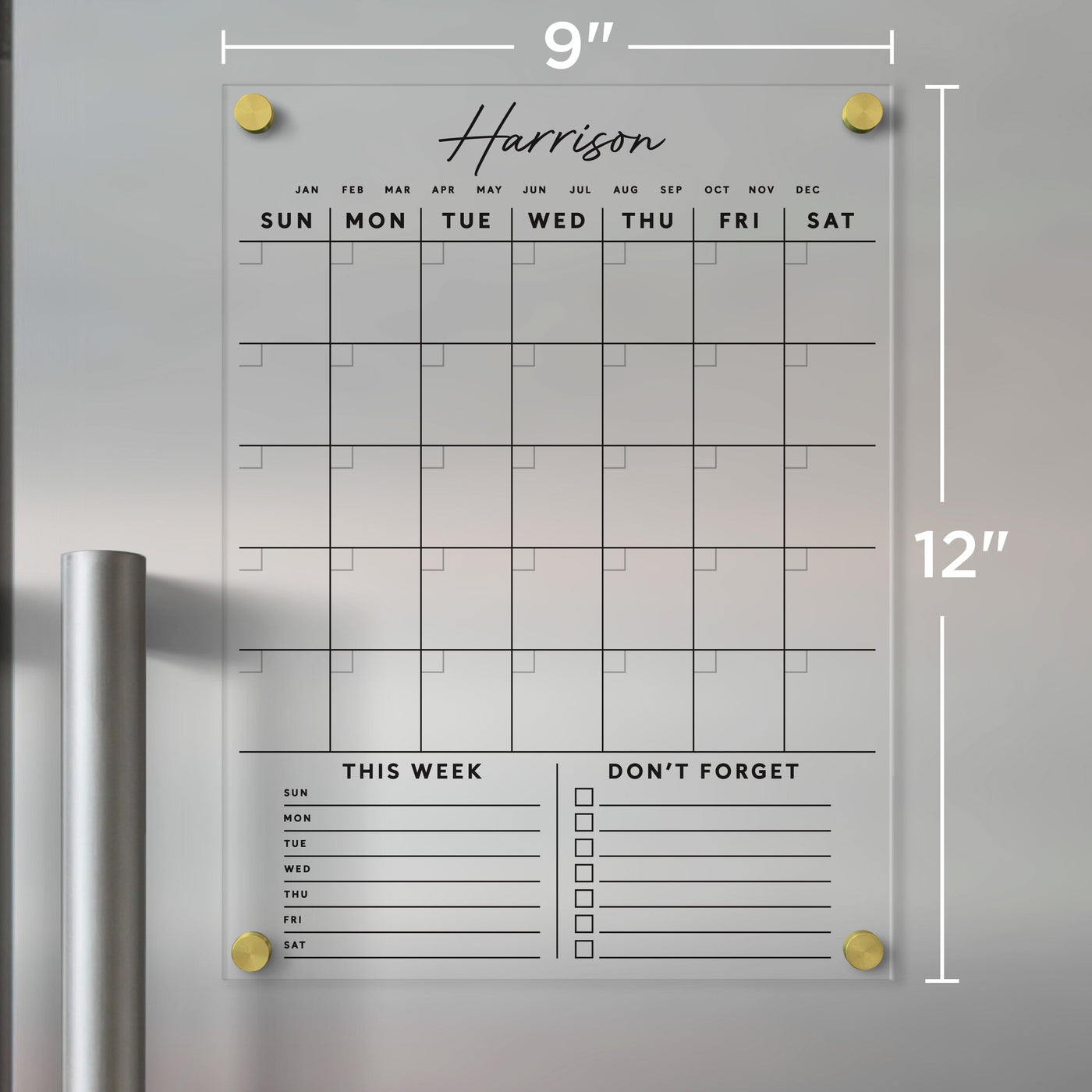 A Clear Acrylic Monthly Fridge Calendar by Girl Friday features Harrison etched on top, sections titled This Week and Dont Forget, measuring 9x12 inches, attaching with gold pegs. Ideal for organizing your week, it works with dry-erase markers.