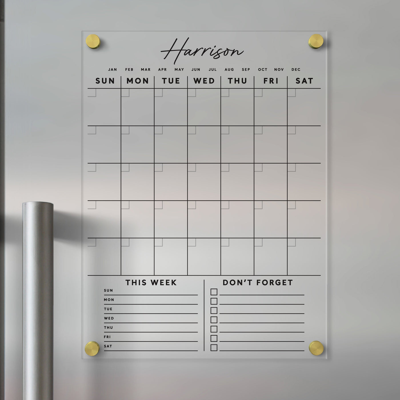 The Clear Acrylic Monthly Fridge Calendar from Girl Friday helps organize busy days with customizable family names and bottom sections. It features daily spaces, This Week, and Dont Forget checkboxes, all writable with dry-erase markers and enhanced by elegant black text.
