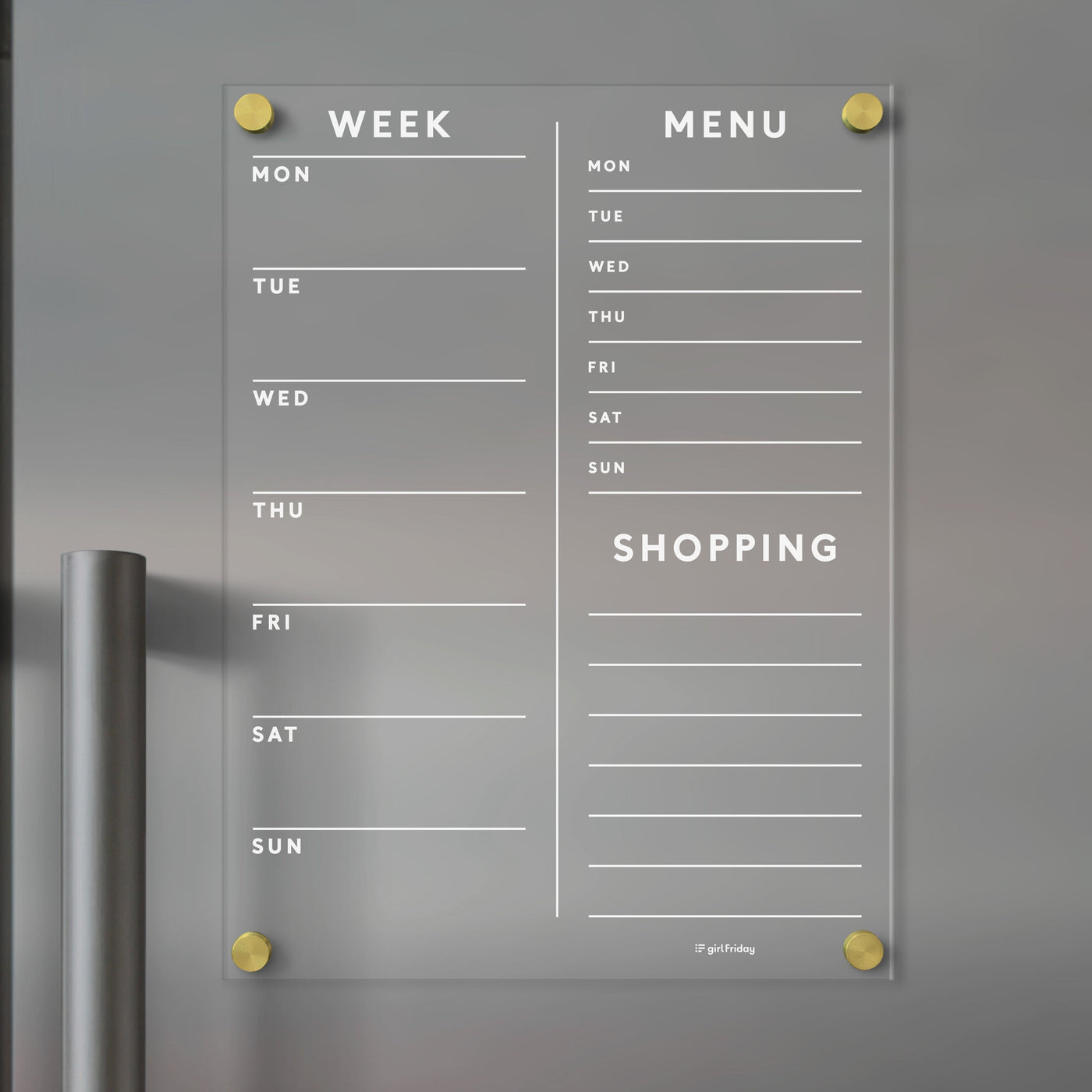 The Girl Friday Acrylic Fridge Planner is a customizable, wall-mounted acrylic planner featuring Week, Menu, and Shopping sections with days of the week. It uses gold pegs for mounting, making it perfect for dry-erase markers.