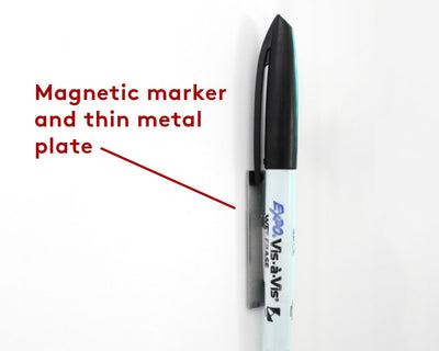 A black-capped Expo Vis-a-Vis magnetic marker, ideal for wet-erase use, is attached to a thin metal plate on a white surface. Its magnetic feature is perfect for the Girl Friday Clear Acrylic Customizable Memo Board | Horizontal.