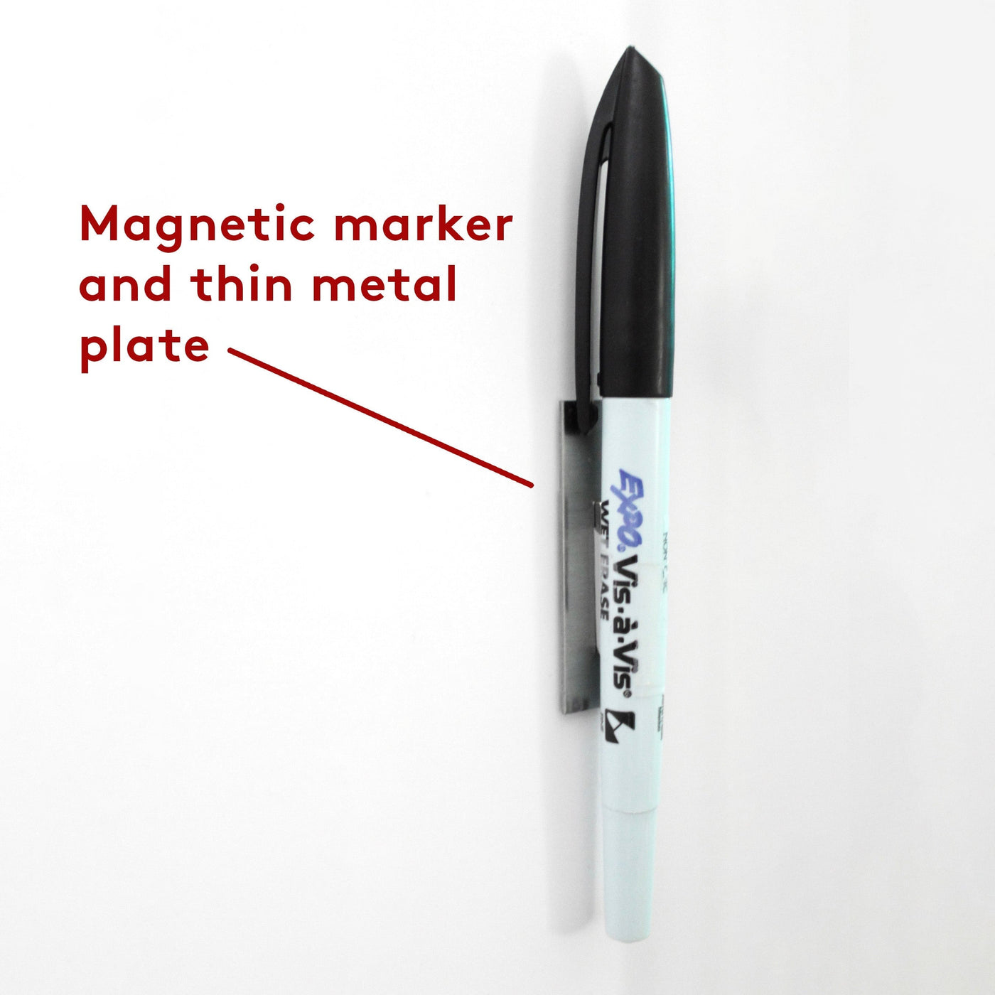 A black and white magnetic marker is attached vertically to the wall using a thin metal plate on the White Acrylic Monthly Calendar by Girl Friday Shop. Text indicates, Magnetic marker and thin metal plate.