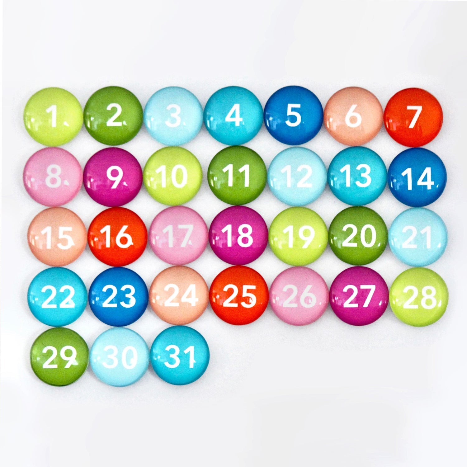 The 36 x 24 Framed Whiteboard Calendar by CalendarGirlCompany has colorful circular magnets numbered 1-31, featuring vibrant shades like green, blue, red, pink, and purple against premium acrylic. Each magnet has a unique white number and is ideal for use with a chalk ink marker set.
