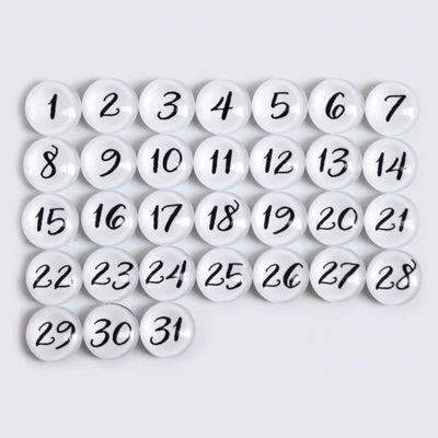 The CalendarGirlCompanys 24 X 18 Framed Whiteboard Calendar #18203 features a neat grid of 31 premium acrylic white circular magnets, each with black numbers from 1 to 31, set against a light gray background for an elegant display.