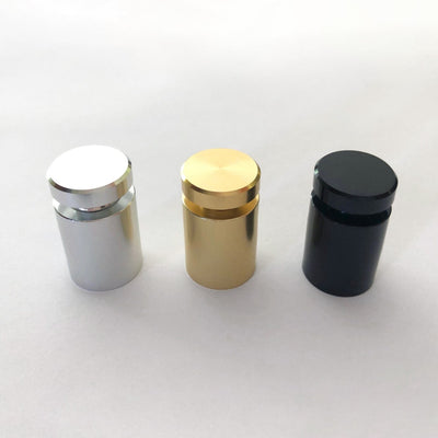 Three cylindrical standoffs, crafted from high-quality materials, are displayed on a white surface. From left to right, they are silver, gold, and black, boasting smooth reflective surfaces and flush tops. Perfect for enhancing home organization with style and elegance using the Clear Acrylic Monthly Wall Calendar with Notes from Girl Friday Shop—now 60% off!.