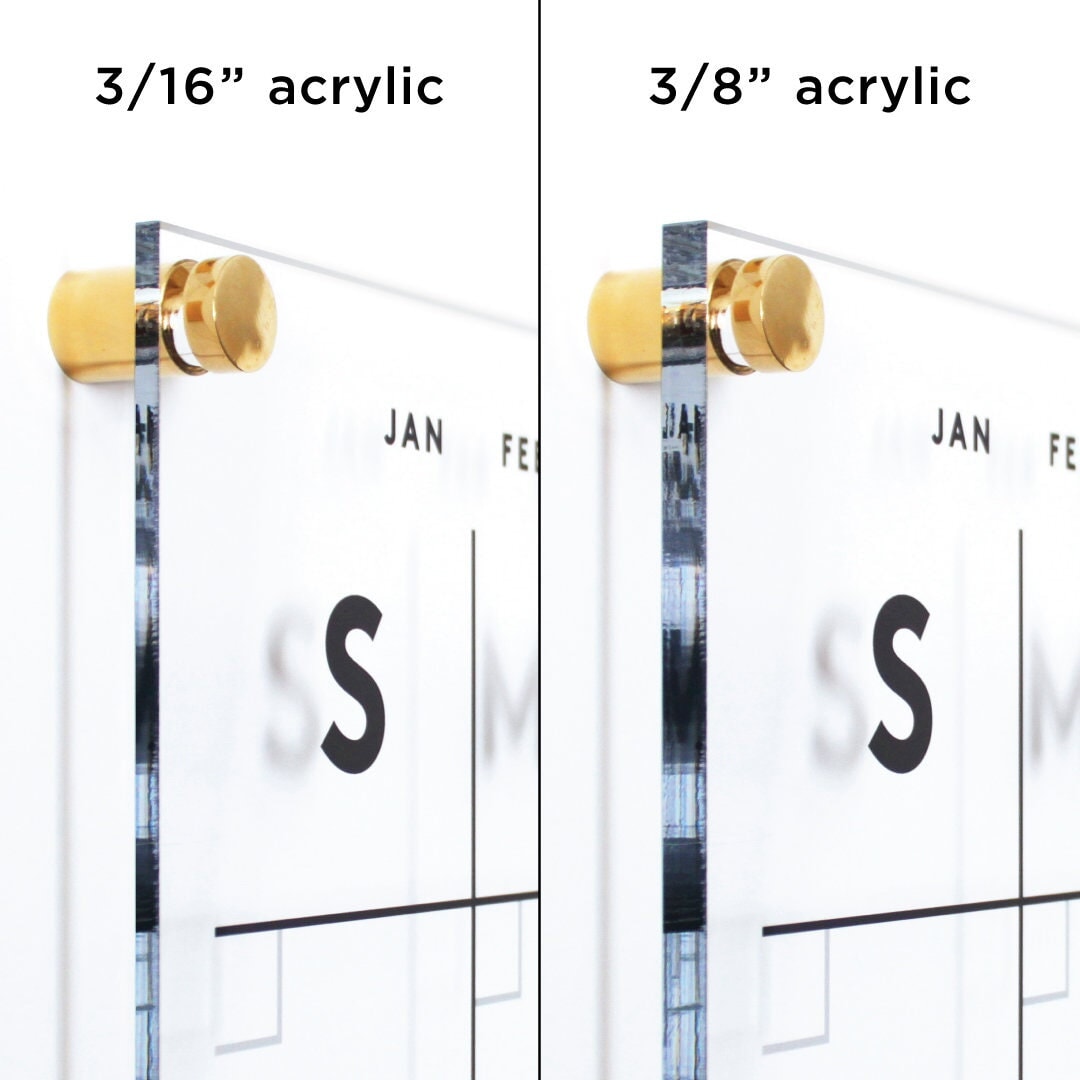 Side-by-side comparison of Girl Fridays Clear Acrylic Monthly Wall Calendar with 2 sections. The left, labeled 3/16” acrylic, is thinner than the right 3/8” acrylic. Both are mounted with gold hardware and feature a printed design suitable for wet-erase markers for ghost-free erasing.