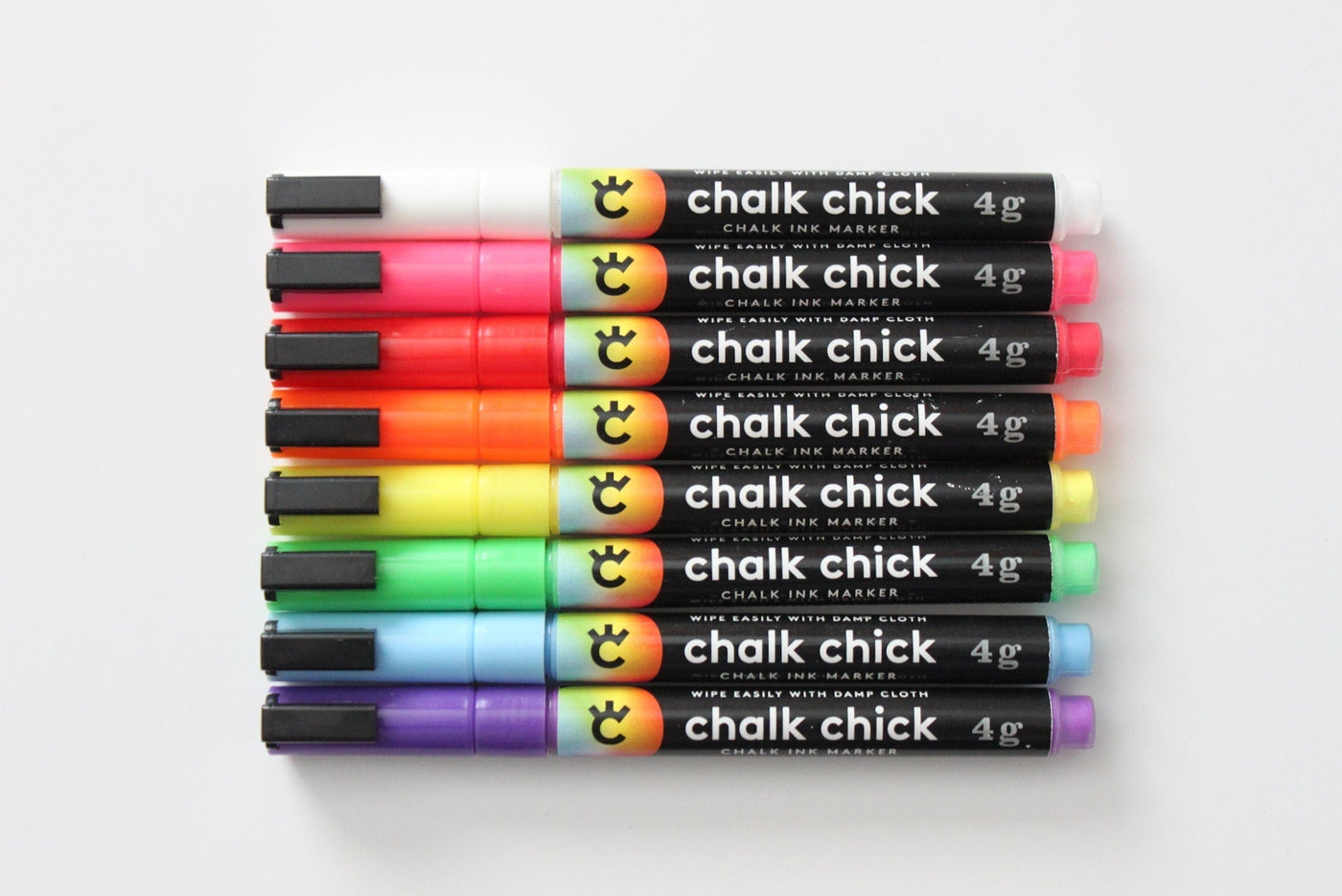 A set of eight vibrant Chalk Chick markers, ideal for your Girl Friday Acrylic Fridge Planner, comes in colors like black and red. These sleek markers, complete with the logo on their black casing, are perfect for adding color to your customizable planner sections.